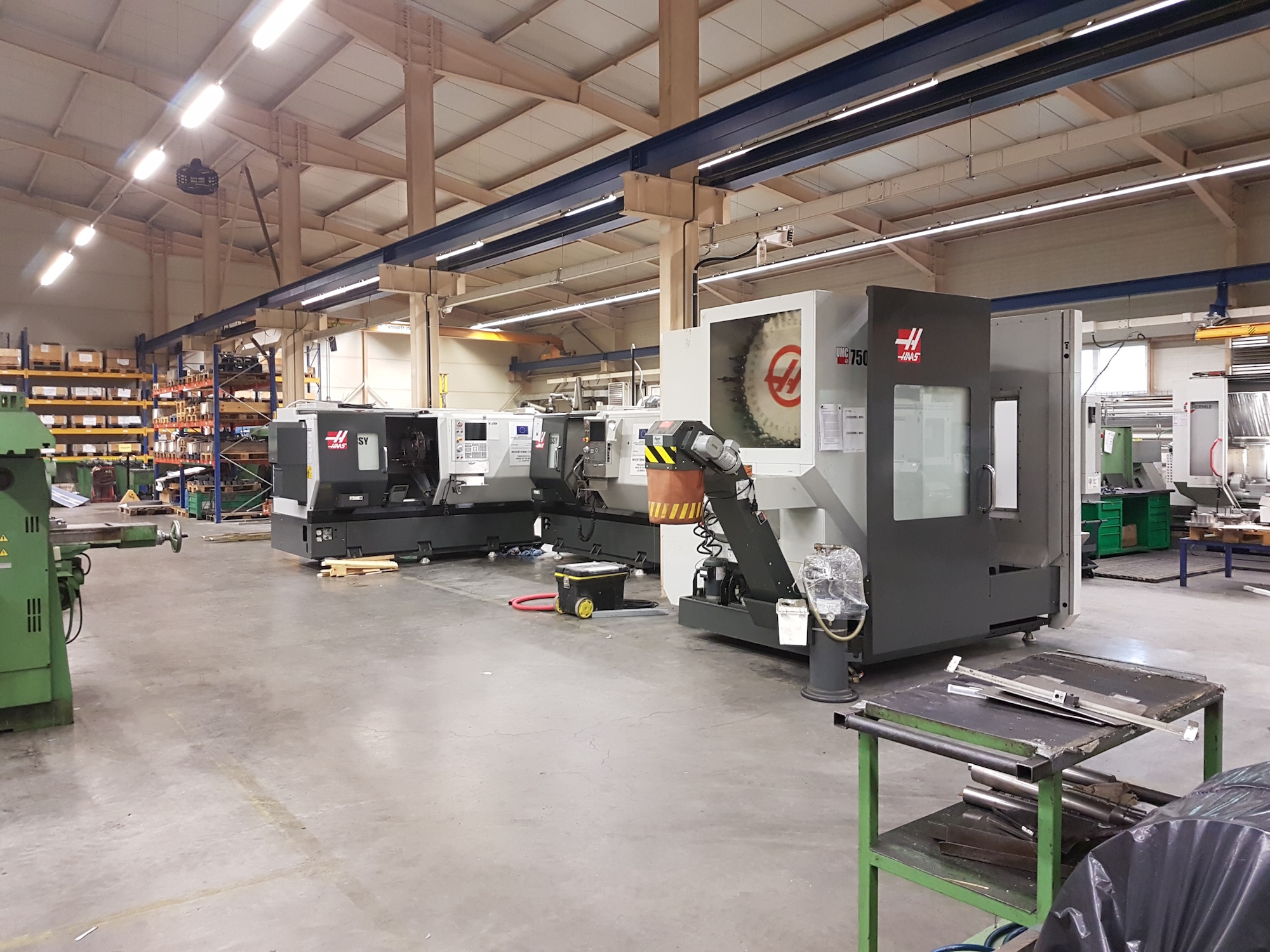 modern CNC machining center in industrial factory, precise metalworking equipment, professional industrial photography, blue lighting