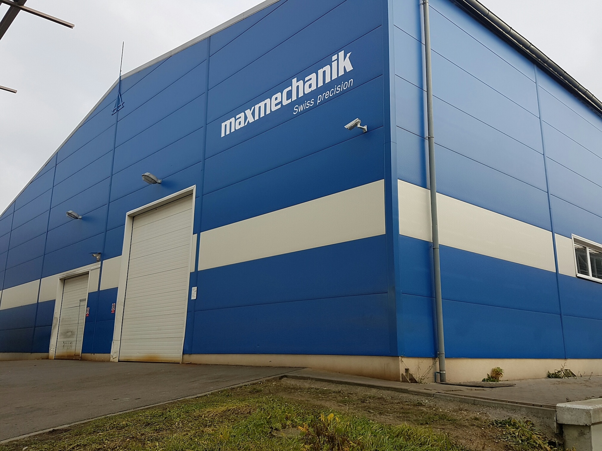 modern industrial factory interior, CNC machines, professional team working, high-tech manufacturing environment, blue industrial lighting